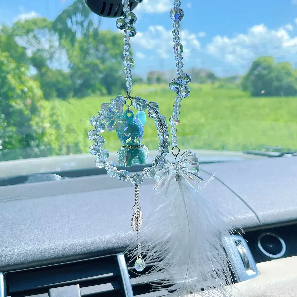 A cute car hanging decoration with a deer, a flower and feathers. It's a lovely rearview mirror car accessory for goddesses.