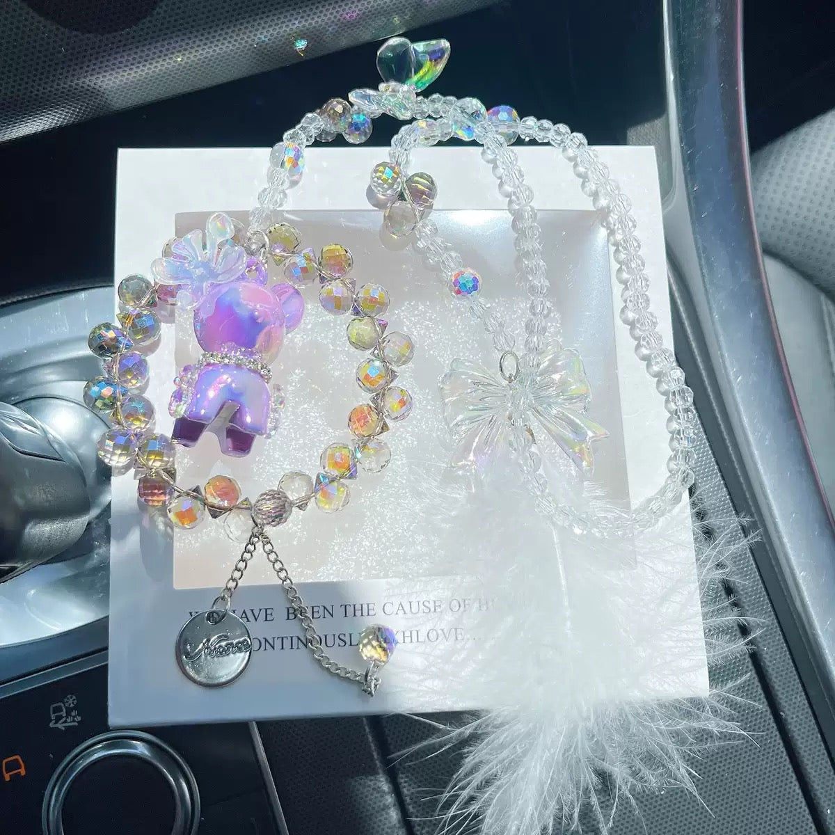 A cute car hanging decoration with a deer, a flower and feathers. It's a lovely rearview mirror car accessory for goddesses.